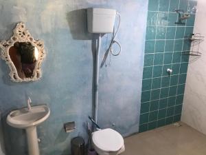 a bathroom with a sink and a toilet and a mirror at Camping Refúgio Shakti II in Florianópolis