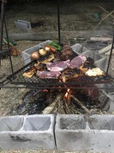 a grill with meat and vegetables on it at Camping Refúgio Shakti II in Florianópolis
