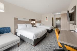 Holiday Inn Express Hotel & Suites-Edmonton South, an IHG Hotel في إيدمونتون: غرفة فندقية بسريرين وتلفزيون بشاشة مسطحة