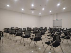 um quarto com filas de cadeiras numa sala de aula em Hotel Royal Elim International em Cali