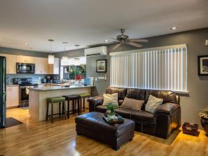 a living room with a couch and a kitchen at Ho'onani Pua Hale in Waipahu