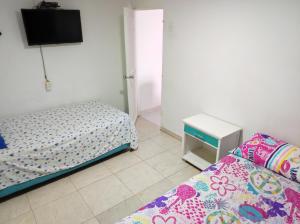sypialnia z dwoma łóżkami i telewizorem na ścianie w obiekcie casa alison w mieście Cartagena de Indias