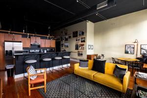 a living room with a yellow couch and a kitchen at The C-Street Archive in Springfield