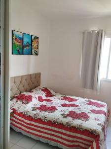 a bed in a bedroom with two pictures on the wall at Pier Jacuípe Residencial in Camaçari