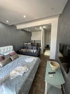 een slaapkamer met een bed, een bank en een tafel bij Deluxe Apartments & Spa in Ulcinj