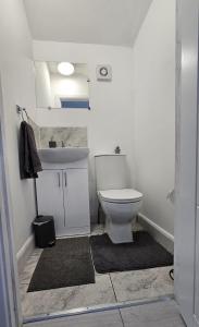 a bathroom with a white toilet and a sink at The Crescent, 3 bed house with 2-3 parking spaces, great for contractors and family in Kent