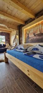 a bedroom with a bed in a log cabin at Babiogórskie Domki in Lipnica Wielka