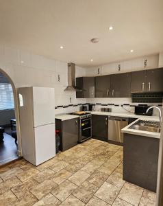 a kitchen with stainless steel appliances and gray cabinets at The Crescent, 3 bed house with 2-3 parking spaces, great for contractors and family in Kent