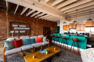 a living room with a couch and a kitchen at The Boho Loft in Springfield