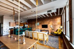 a living room with a table and a brick wall at The Boho Loft in Springfield