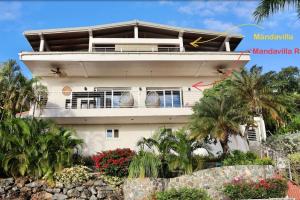 un edificio blanco con palmeras delante en Mandavilla Rose - Inspired USVI, en Cruz Bay