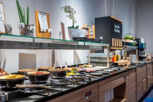 a buffet line with pots and pans of food at Park Inn By Radisson Wismar in Wismar