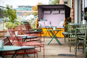 eine Gruppe von Stühlen und Tischen auf einem Balkon in der Unterkunft Park Inn By Radisson Wismar in Wismar