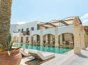 eine Villa mit einem Pool und einem Resort in der Unterkunft Grecotel Plaza Beach House in Rethymno