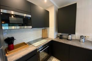a kitchen with black cabinets and a counter top at Aesthetics - 2 bedrooms and secure parking! in Montpellier