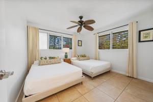 a bedroom with two beds and a ceiling fan at International Colony Club 37 in Kaanapali