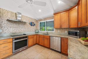 a kitchen with wooden cabinets and stainless steel appliances at International Colony Club 37 in Kaanapali