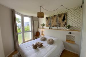 a bedroom with a white bed with towels on it at Aesthetics - 2 bedrooms and secure parking! in Montpellier