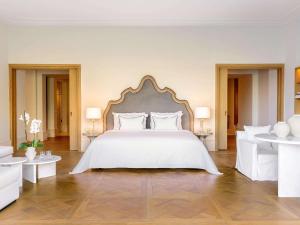 een slaapkamer met een groot wit bed en witte meubels bij Corfu Imperial, Grecotel Beach Luxe Resort in Kommeno