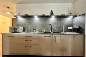 a kitchen with stainless steel cabinets and a sink at Appartement GABIN in Aubenas