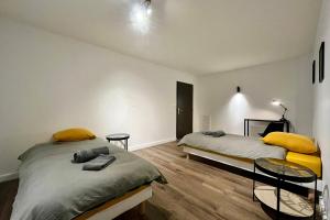 a bedroom with two beds and two tables in it at Appartement GABIN in Aubenas