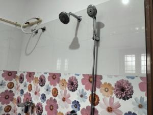 een douche met twee microfoons in een badkamer bij Devi Kripa Residency in Varkala