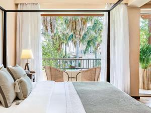 a bedroom with a bed and a large window at Grecotel Filoxenia Hotel in Kalamata