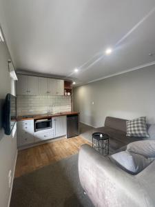 a living room with a couch and a kitchen at Guest Wing in Richmond Downs in Walton +5 photos