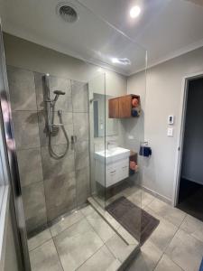 a bathroom with a shower and a sink at Guest Wing in Richmond Downs in Walton