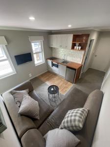 a living room with a couch and a kitchen at Guest Wing in Richmond Downs in Walton