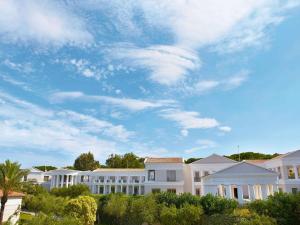 a row of white houses under a cloudy sky w obiekcie Grecotel La Riviera at Riviera Olympia & Aqua Park w mieście Loutra Killinis