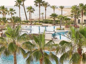 uma vista para um resort com palmeiras e o oceano em Grecotel La Riviera & Aqua Park em Loutra Killinis
