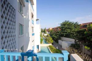 un balcone con vista sulla piscina di un edificio di The Chelona a Khao Tao