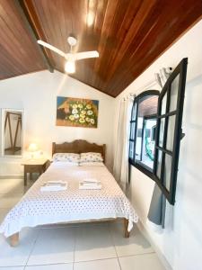 a bedroom with a bed and a window at Baluarte Suites in Búzios