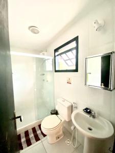 ein Bad mit einem WC, einem Waschbecken und einer Dusche in der Unterkunft Baluarte Suites in Búzios