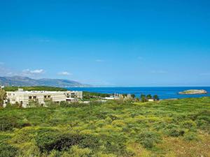 a house on a hill next to the ocean at Grecotel Meli Palace in Sisi