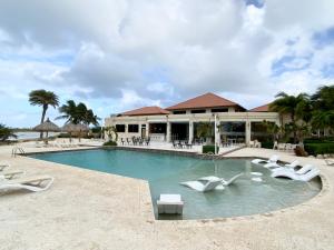 a resort with a swimming pool and lounge chairs at Casa Azure Aruba in Palm-Eagle Beach