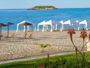 a group of umbrellas and chairs on a beach at Grecotel Meli Palace in Sisi