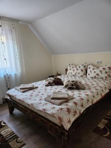 a bedroom with a large bed with a comforter at Casa din livadă - Cazare Măgheruș in Topliţa