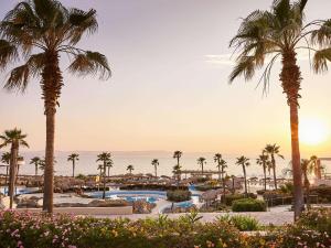 a view of a resort with palm trees and the ocean at Grecotel Olympia Oasis & Aqua Park in Loutra Killinis