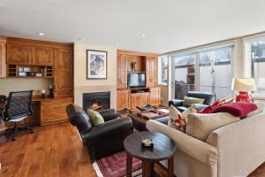 a living room with a couch and a fireplace at Spring Street Unit 629, 2BR Condo w/ Mountain Views and Door Step Access to Shops & Restaurants in Aspen