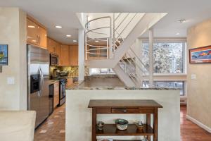 a kitchen with a spiral staircase in a house at Spring Street Unit 629, 2BR Condo w/ Mountain Views and Door Step Access to Shops & Restaurants in Aspen