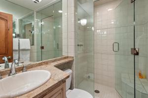 a bathroom with a sink and a glass shower at Spring Street Unit 629, 2BR Condo w/ Mountain Views and Door Step Access to Shops & Restaurants in Aspen +15 photos