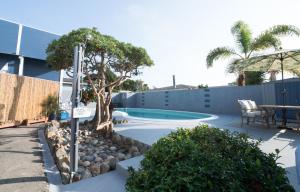 - une piscine avec un arbre à côté d'un bâtiment dans l'établissement * - The Leucadia Beach Grotto - * An Encinitas Gem, à Encinitas