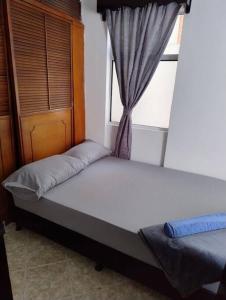 Bett in einem Zimmer mit Fenster in der Unterkunft comodidad y ubicación. in Medellín