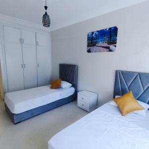 een slaapkamer met 2 bedden en een foto aan de muur bij Luxury Apartement in City Center F2 in Tanger