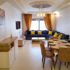 a living room with a table and a blue couch at Luxury Apartement in City Center F2 in Tangier