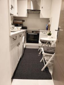 cocina con armarios blancos y alfombra negra en Central London property-ensuite, double and budget room, en Londres