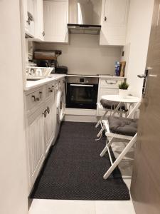 a kitchen with white cabinets and a black rug at Central London property-ensuite, double and budget room in London