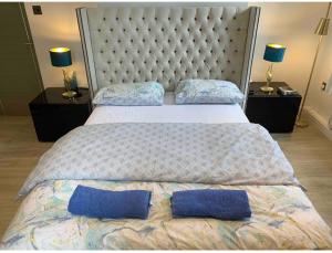 1 cama grande con 2 almohadas azules en Central London property-ensuite, double and budget room, en Londres 2 fotos más